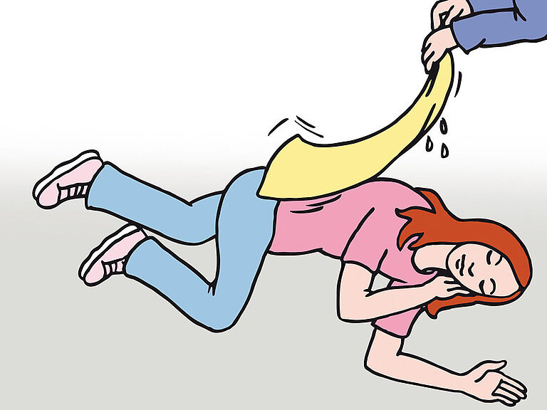 Hitzschlag: Ein Frau liegt in der stabilen Seitenlage, eine Ersthelfer legt ein feuchtes Tuch über Ihren Oberkörper.