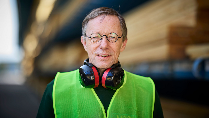Porträt Uwe Pfeiffer, Teamleiter Holzzuschnitt und Sicherheitsbeauftragter bei Holz Possling, hat Gehörschutz um seinen Nacken liegen