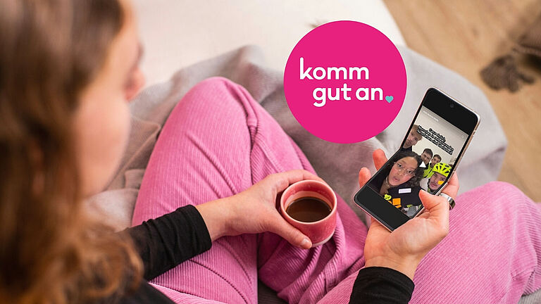 Eine junge Frau im Schneidersitze schaut sich ein TikTok-Video an