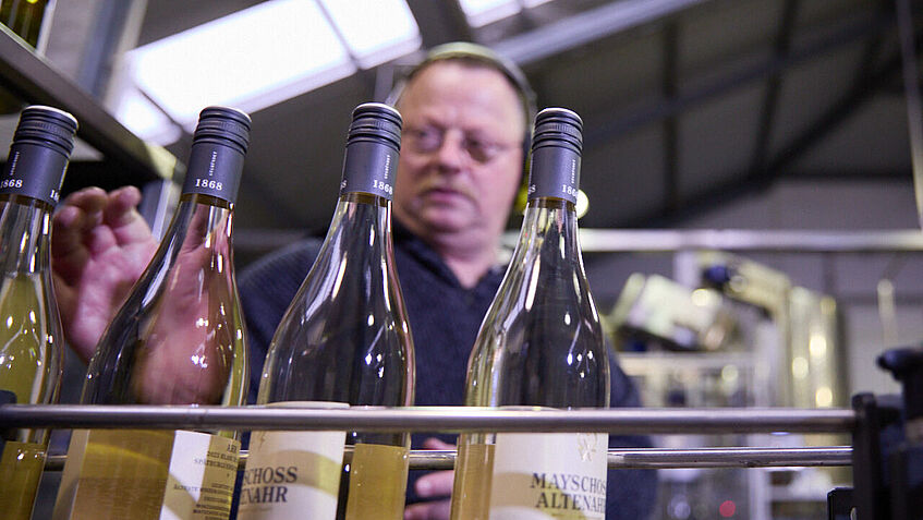 Günter Schumacher, Beschäftigter der Winzergenossenschaft, steht an der Abfüllanlage und überprüft, ob die Flaschen richtig abgefüllt sind. 