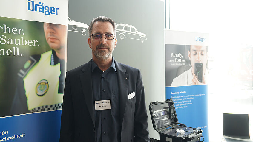 Martin Kröger (Fa. Dräger Safety AG & Co. KGaA) steht vor verschiedenen Displays.